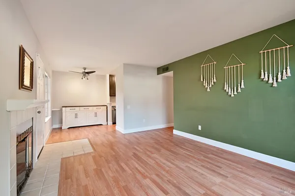 a view of a livingroom with wooden floor and a ceiling fan