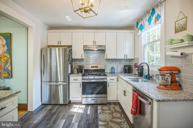 a kitchen with stainless steel appliances granite countertop a sink stove and refrigerator