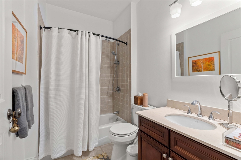391 Walnut Street, Unit 4 Newton, MA 02460 - Photo 18 of 26 a bathroom with a sink a toilet and shower curtain