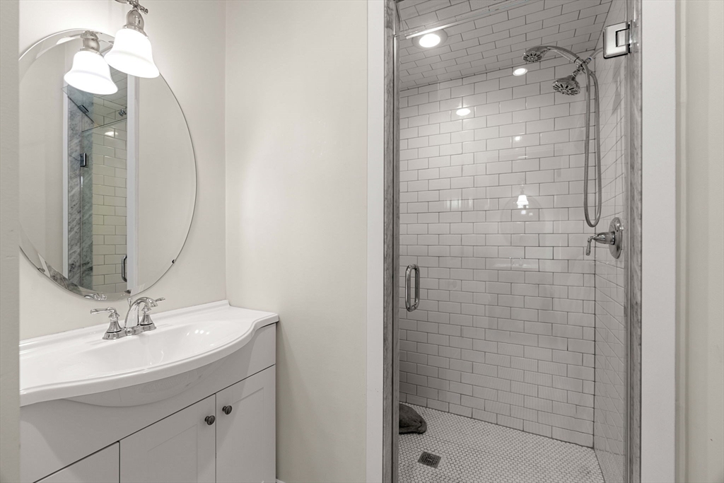 391 Walnut Street, Unit 4 Newton, MA 02460 - Photo 22 of 26 a bathroom with a sink a shower a mirror and a bathtub