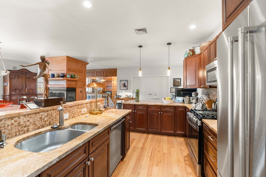 391 Walnut Street, Unit 4 Newton, MA 02460 - Photo 4 of 26 a kitchen with kitchen island granite countertop a sink stove and cabinets