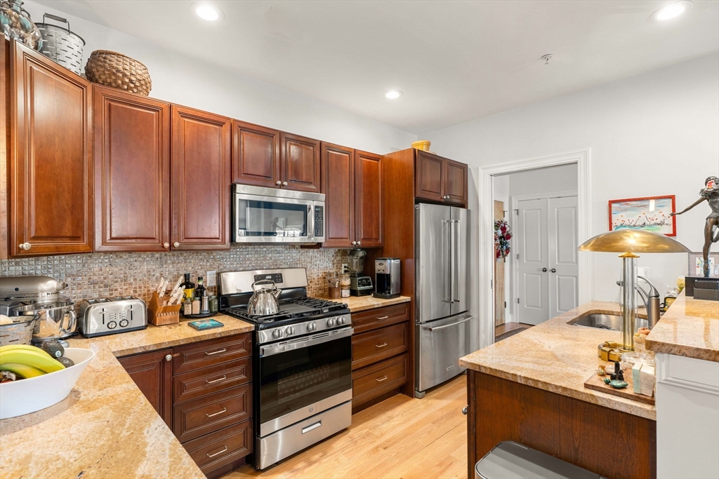 391 Walnut Street, Unit 4 Newton, MA 02460 - Photo 6 of 26 a kitchen with stainless steel appliances granite countertop a stove refrigerator and cabinets