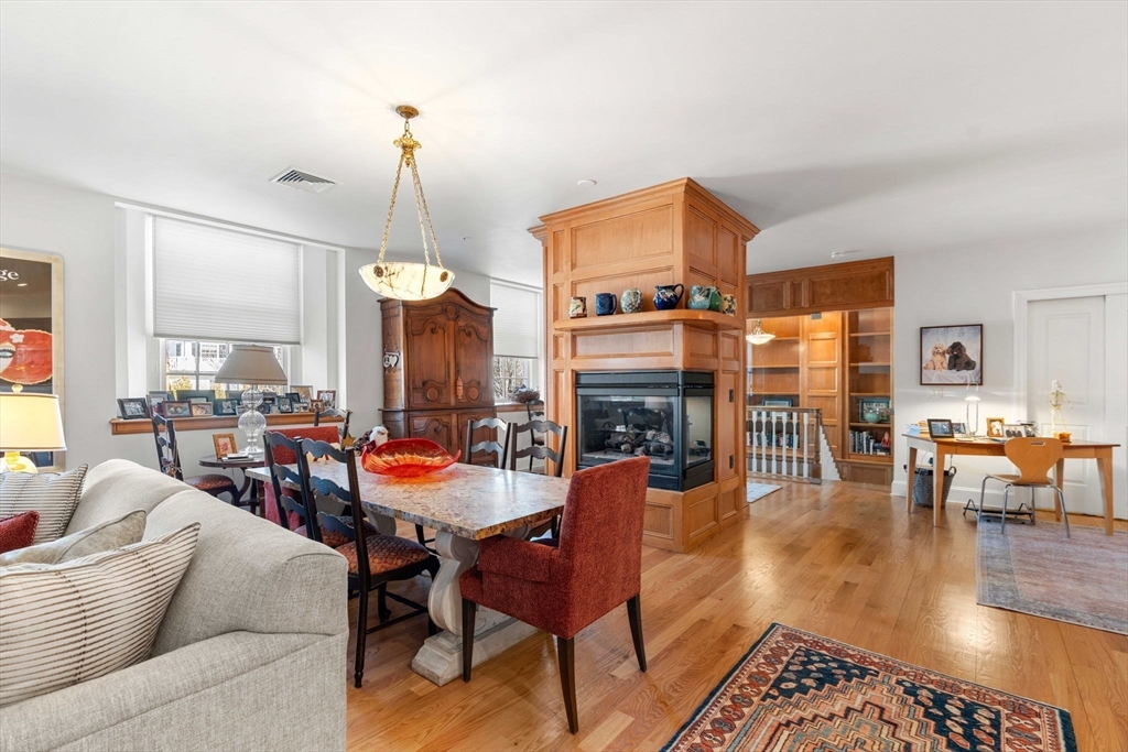 391 Walnut Street, Unit 4 Newton, MA 02460 - Photo 8 of 26 a living room with furniture a fireplace and a dining table with wooden floor