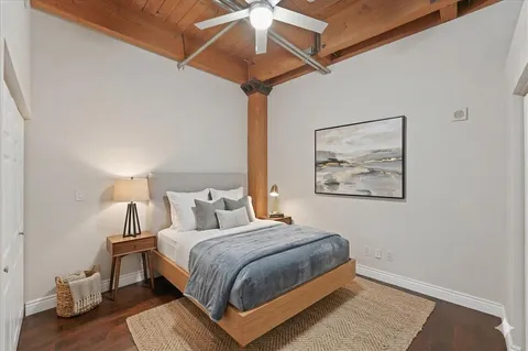 an empty room with wooden floor and fan