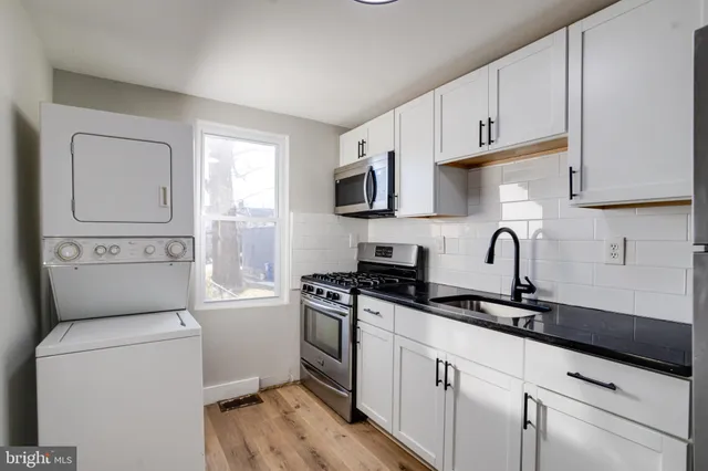a kitchen with granite countertop white cabinets and white appliances