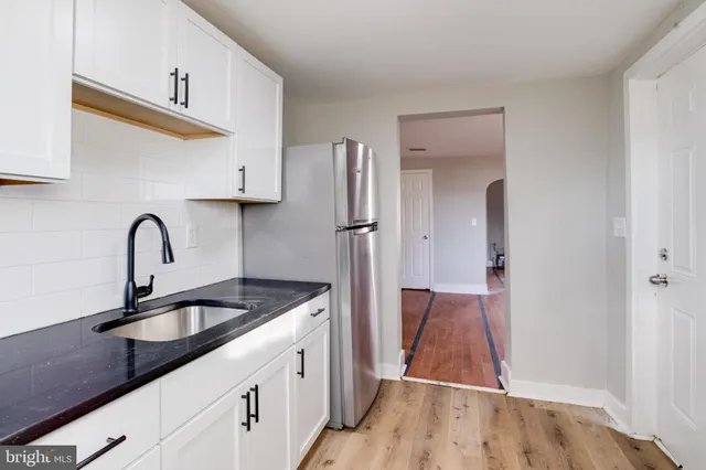 a kitchen with sink a refrigerator and cabinets