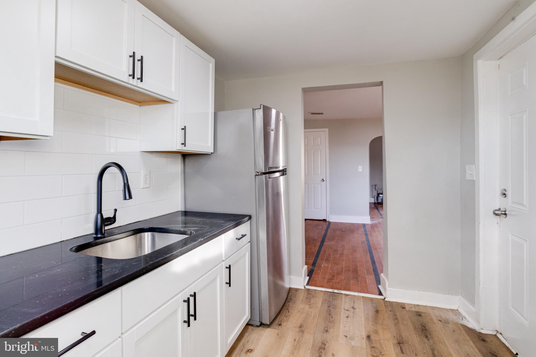 6573 St Helena Avenue Baltimore, MD 21222 - Photo 19 of 37 a kitchen with sink a refrigerator and cabinets