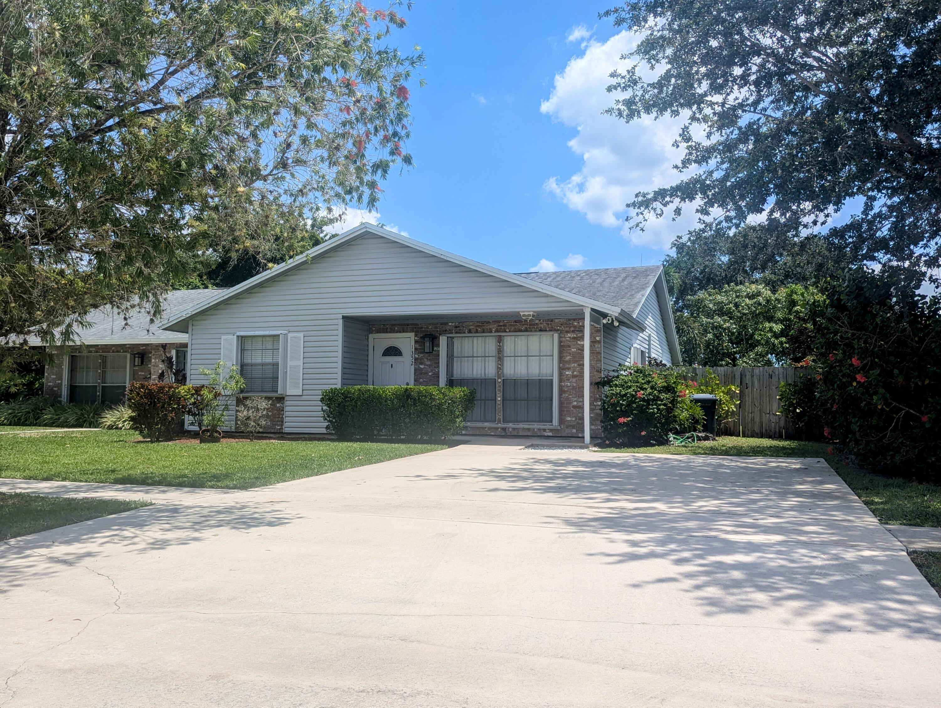 1350 Riverside Circle, Unit S A AND B Wellington, FL 33414 - Photo 2 of 67 a front view of a house with a garden