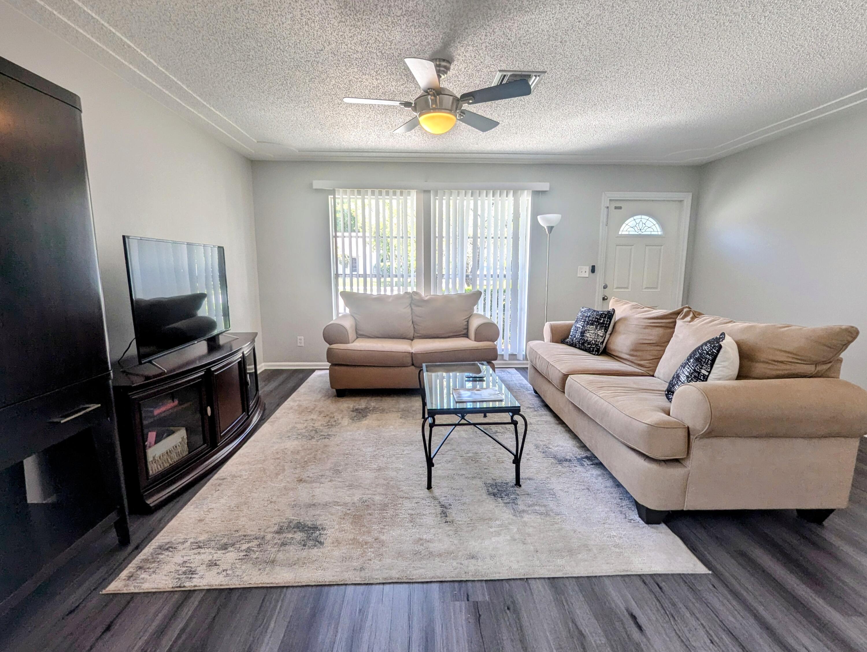 1350 Riverside Circle, Unit S A AND B Wellington, FL 33414 - Photo 7 of 67 a living room with furniture and a flat screen tv