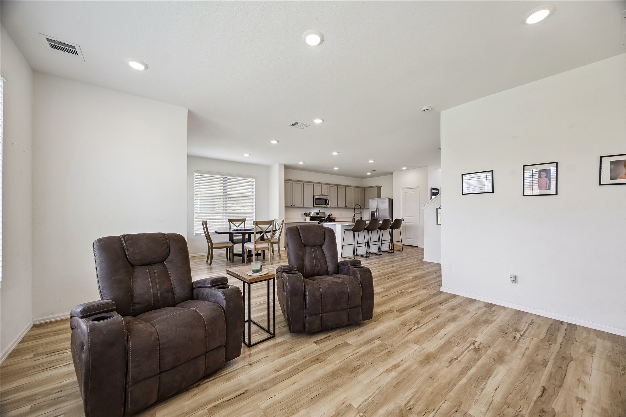 3812 Moss Hl Road Rosenberg, TX 77469 - Photo 2 of 20 This open-concept living area features sleek hardwood floors and a seamless flow into a modern kitchen with stainless steel appliances and a breakfast bar. Ideal for relaxation and entertaining.
