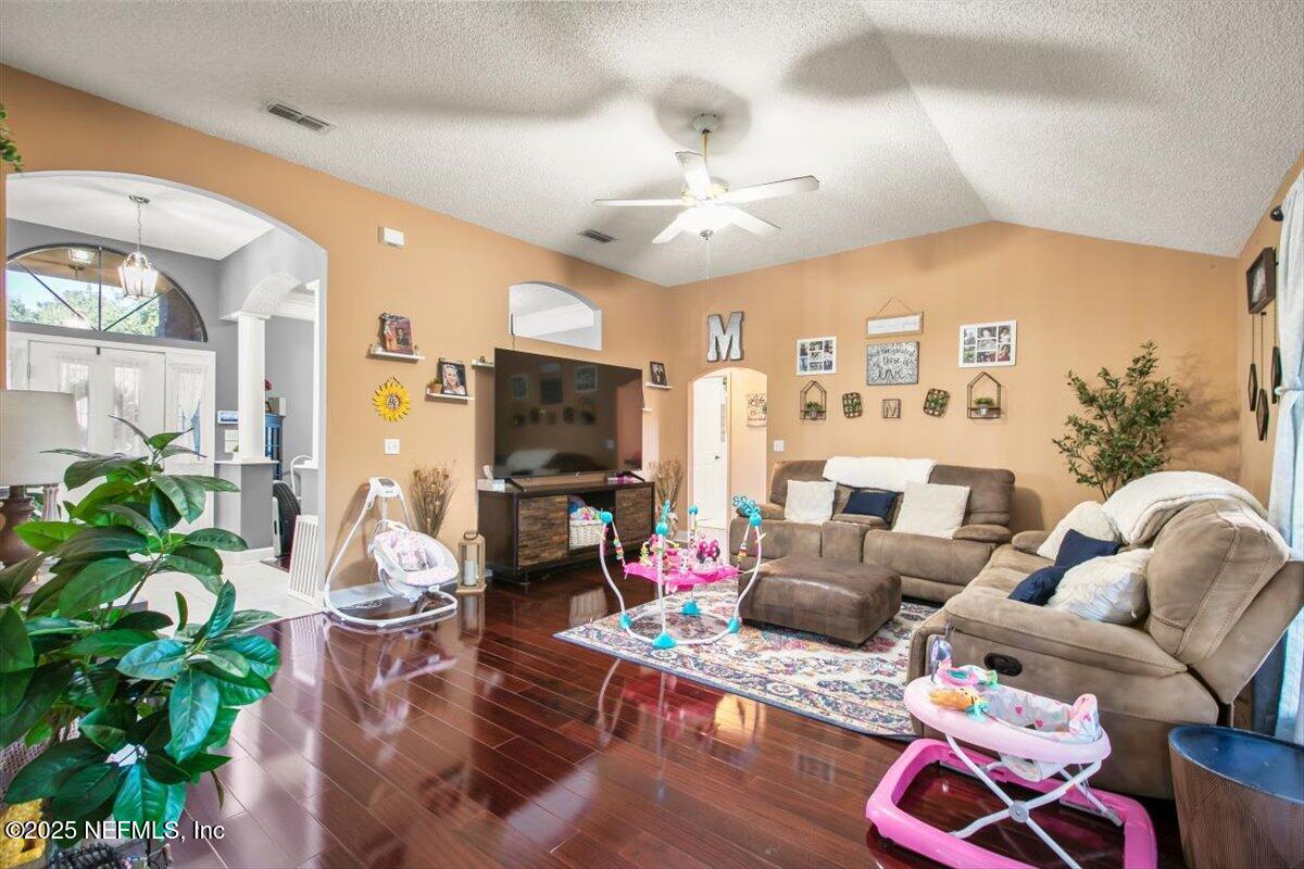 627 Whitfield Road Jacksonville, FL 32221 - Photo 5 of 18 a living room with furniture a chandelier and a flat screen tv