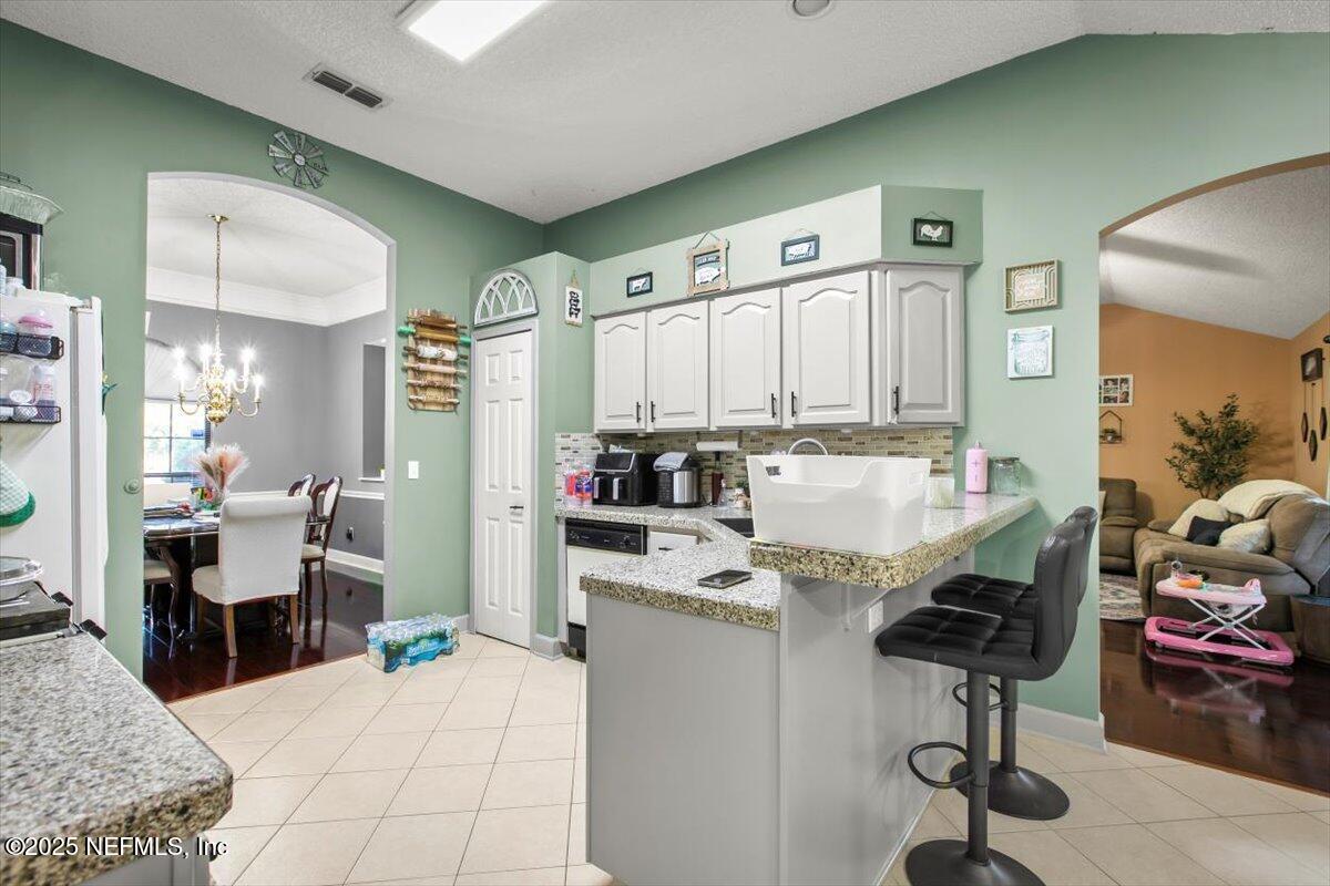 627 Whitfield Road Jacksonville, FL 32221 - Photo 7 of 18 a kitchen with stainless steel appliances kitchen island granite countertop a refrigerator and microwave