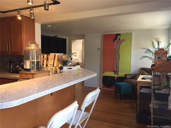 a large living room with kitchen view and a wooden floor