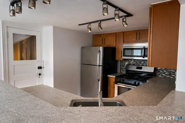 a kitchen with stainless steel appliances a refrigerator and a stove top oven