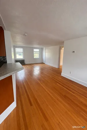 a kitchen with stainless steel appliances granite countertop a refrigerator a stove and a sink with wooden floor
