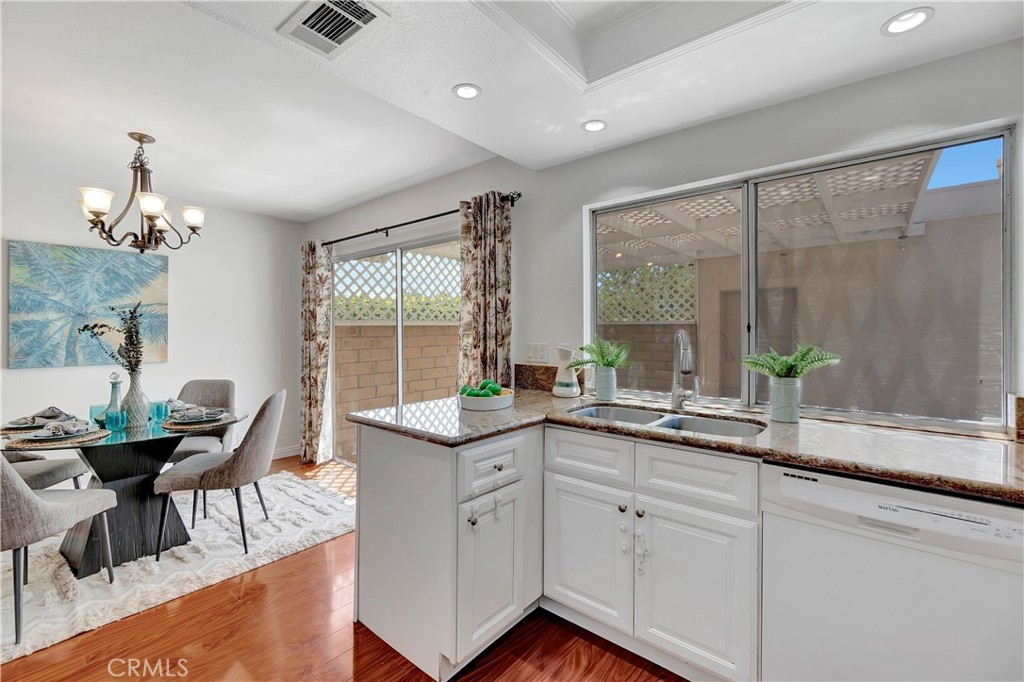30 Silverwood Irvine, CA 92604 - Photo 12 of 32 a kitchen with granite countertop a stove a sink dining table and chairs