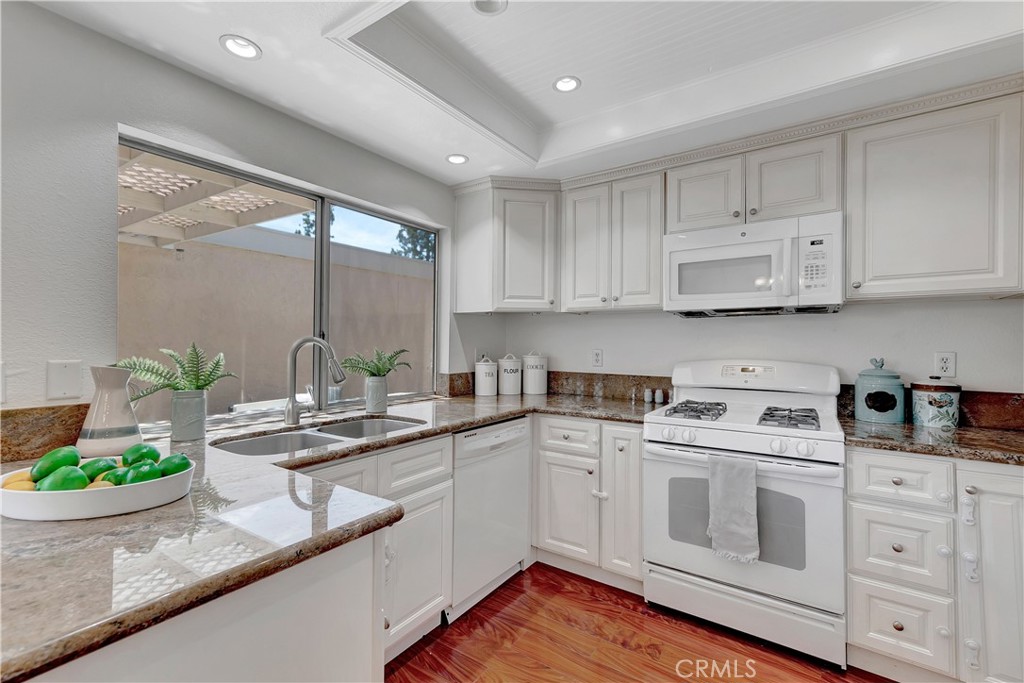 30 Silverwood Irvine, CA 92604 - Photo 15 of 32 a kitchen with white cabinets and white appliances