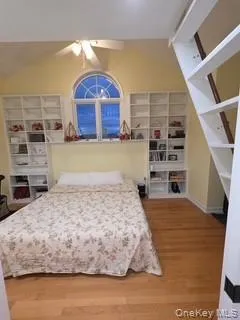 a bedroom with a bed and a view of living room