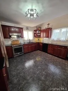 a large kitchen with stainless steel appliances granite countertop a stove and a refrigerator