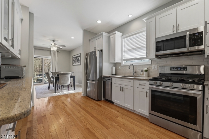 68 Arch Street Butler, NJ 07405 - Photo 7 of 46 a kitchen with stainless steel appliances a stove a sink cabinets and a wooden floor