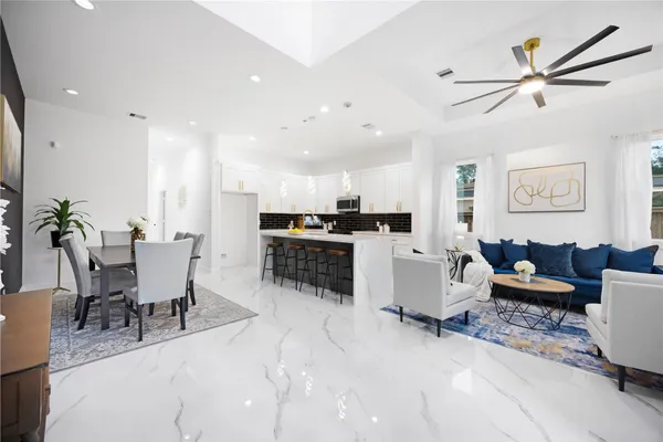a living room with furniture and kitchen view