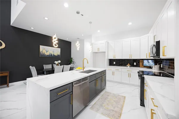a kitchen with a sink a counter top space stainless steel appliances and cabinets