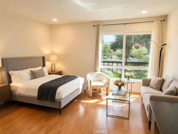 a spacious bedroom with a bed and glass walk in closet