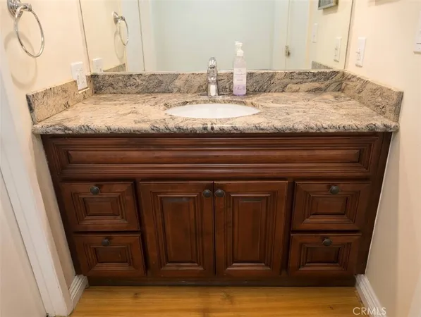 a bathroom with a granite countertop sink and vanity