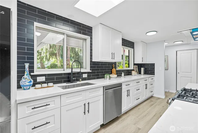 a kitchen with granite countertop a sink stainless steel appliances and cabinets