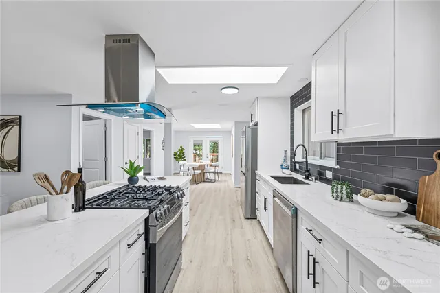 a kitchen with stainless steel appliances a sink stove and cabinets