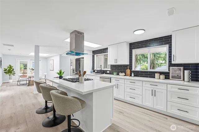 a kitchen with sink cabinets and dining table chairs