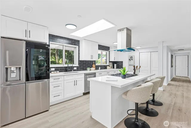 a kitchen with stainless steel appliances kitchen island granite countertop a sink and cabinets