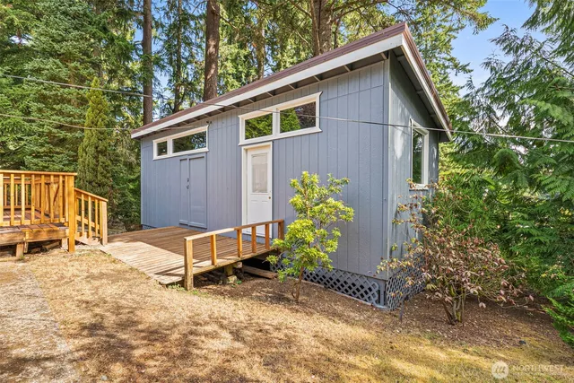 a backyard of a house with wooden fence and large trees