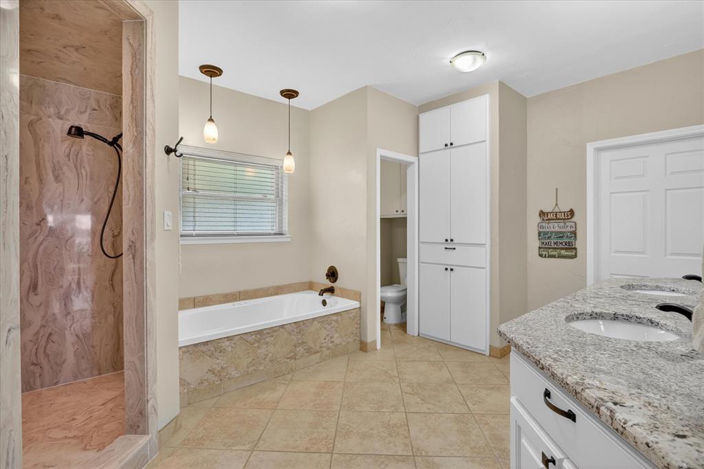 8877 Random Road Fort Worth, TX 76179 - Photo 14 of 40 a spacious bathroom with a granite countertop sink a mirror a bathtub and shower