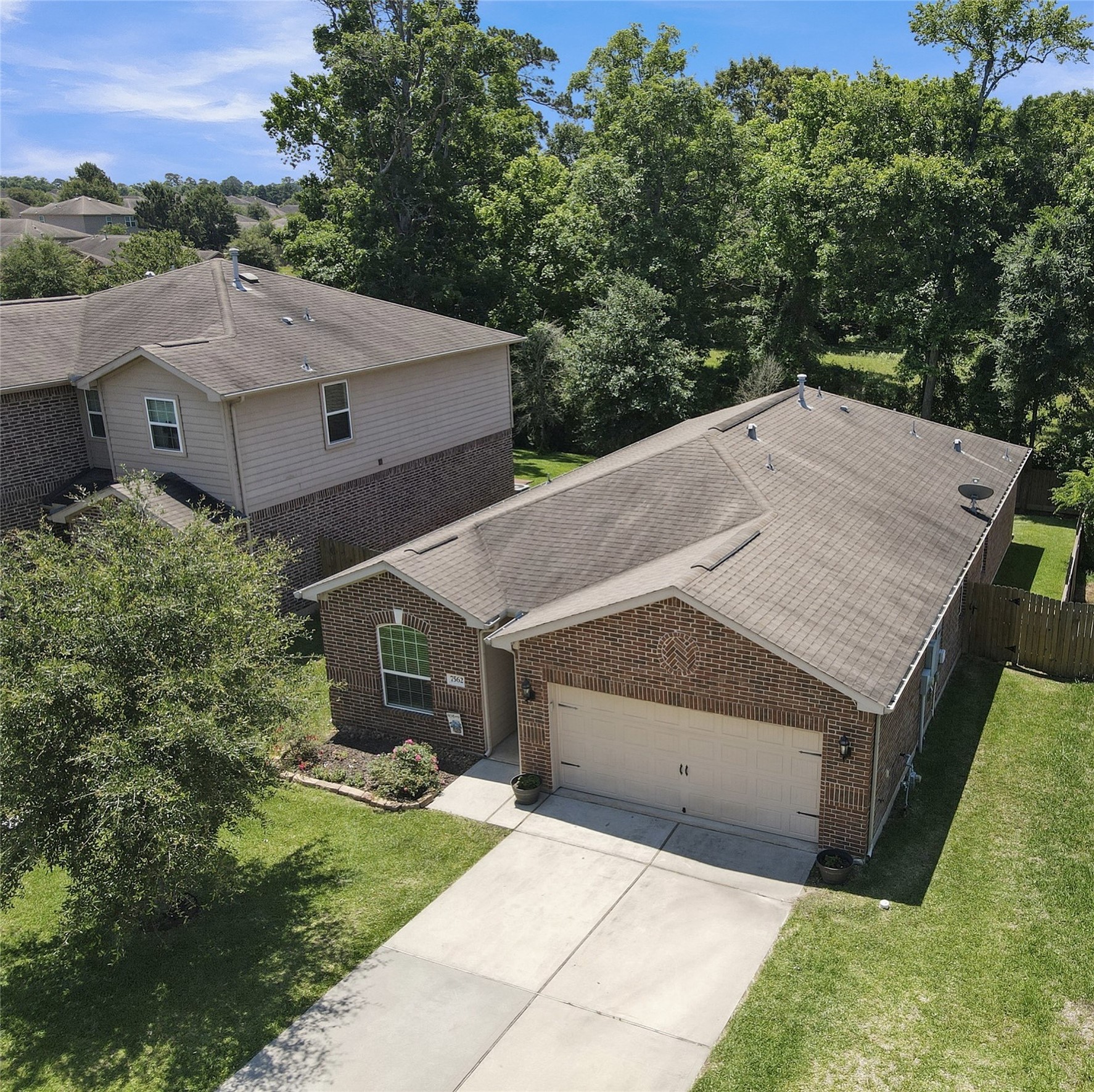 7562 Fettle Lane Conroe, TX 77304 - Photo 25 of 30 Aerial exterior perspective highlighting the home’s location, privacy, and surrounding natural scenery.
