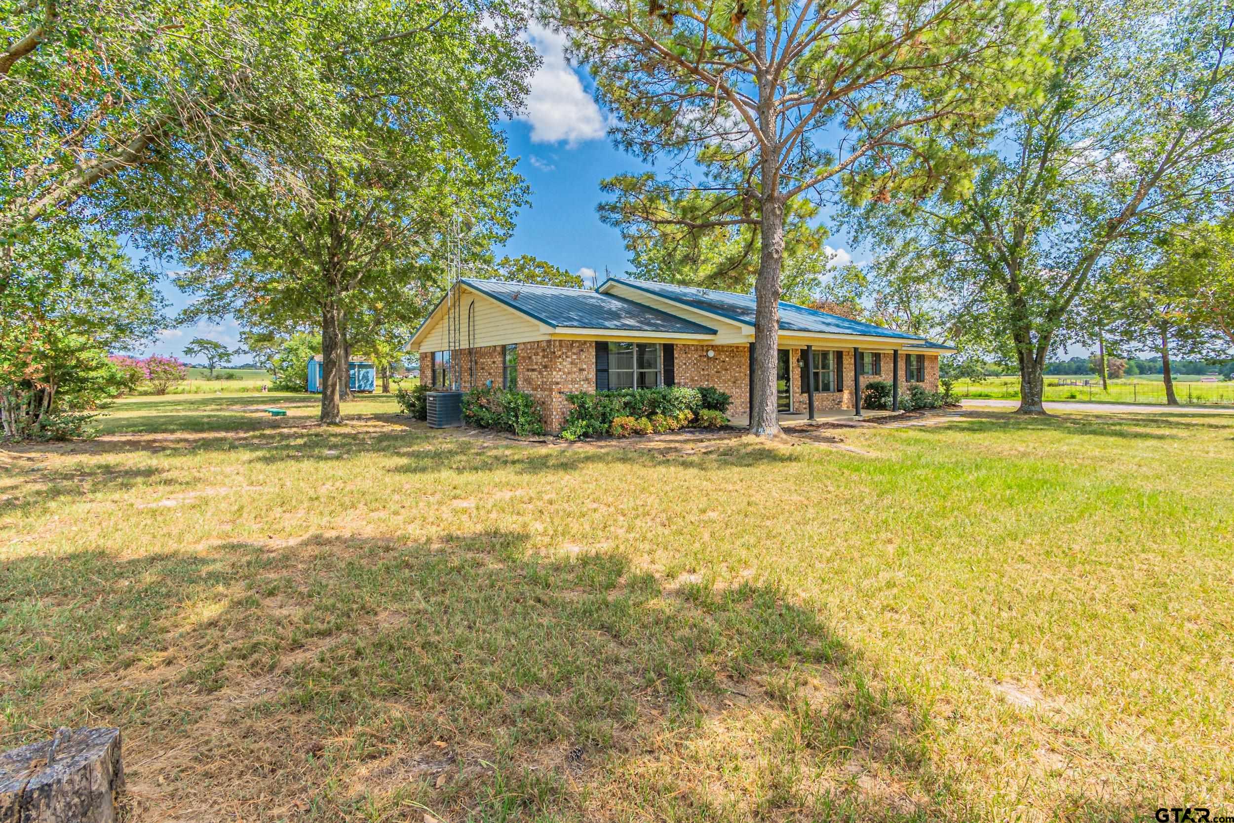 a front view of a house with swimming pool and trees