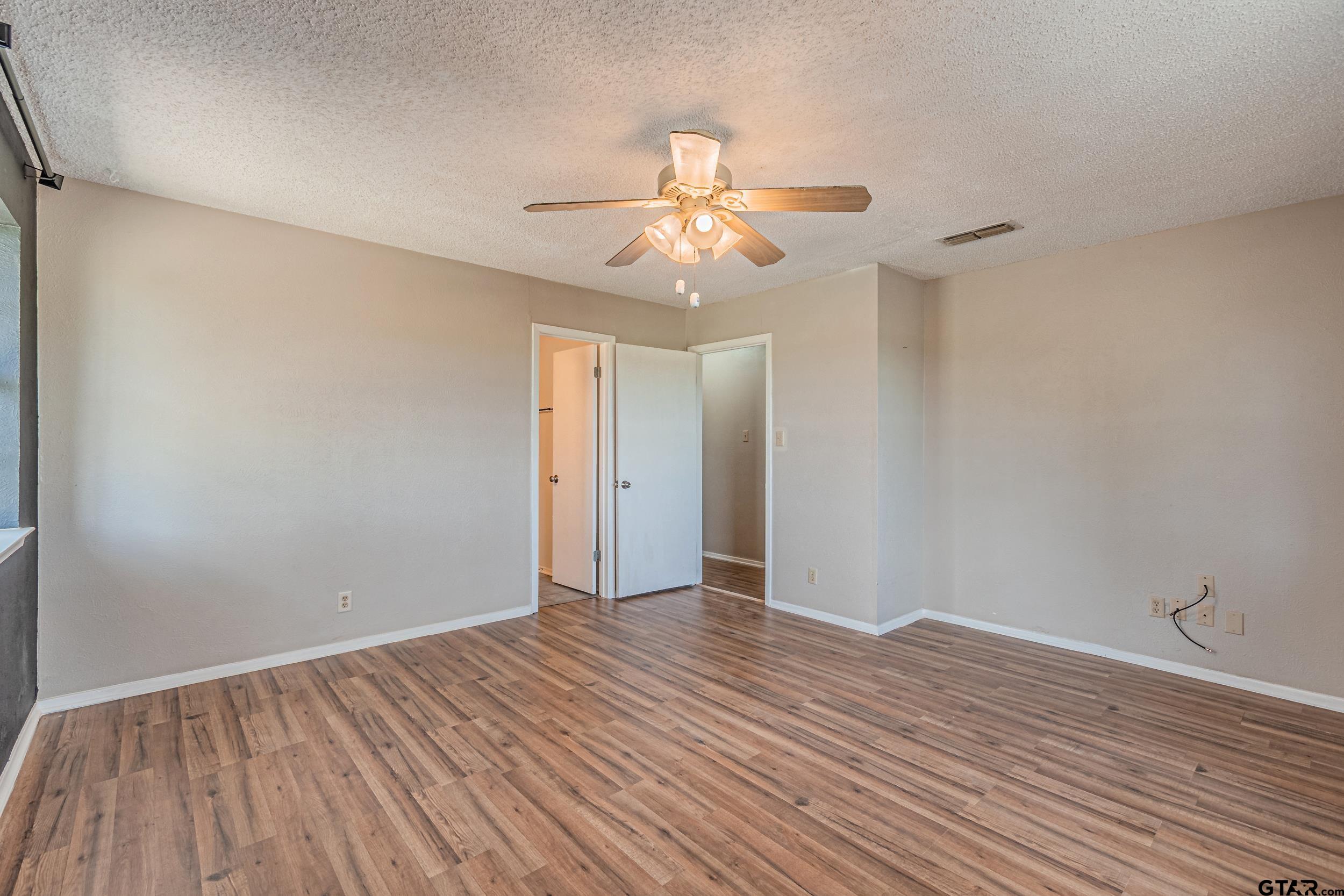 401 VZ County Road Canton, TX 75103 - Photo 35 of 45 a view of an empty room with wooden floor and a ceiling fan
