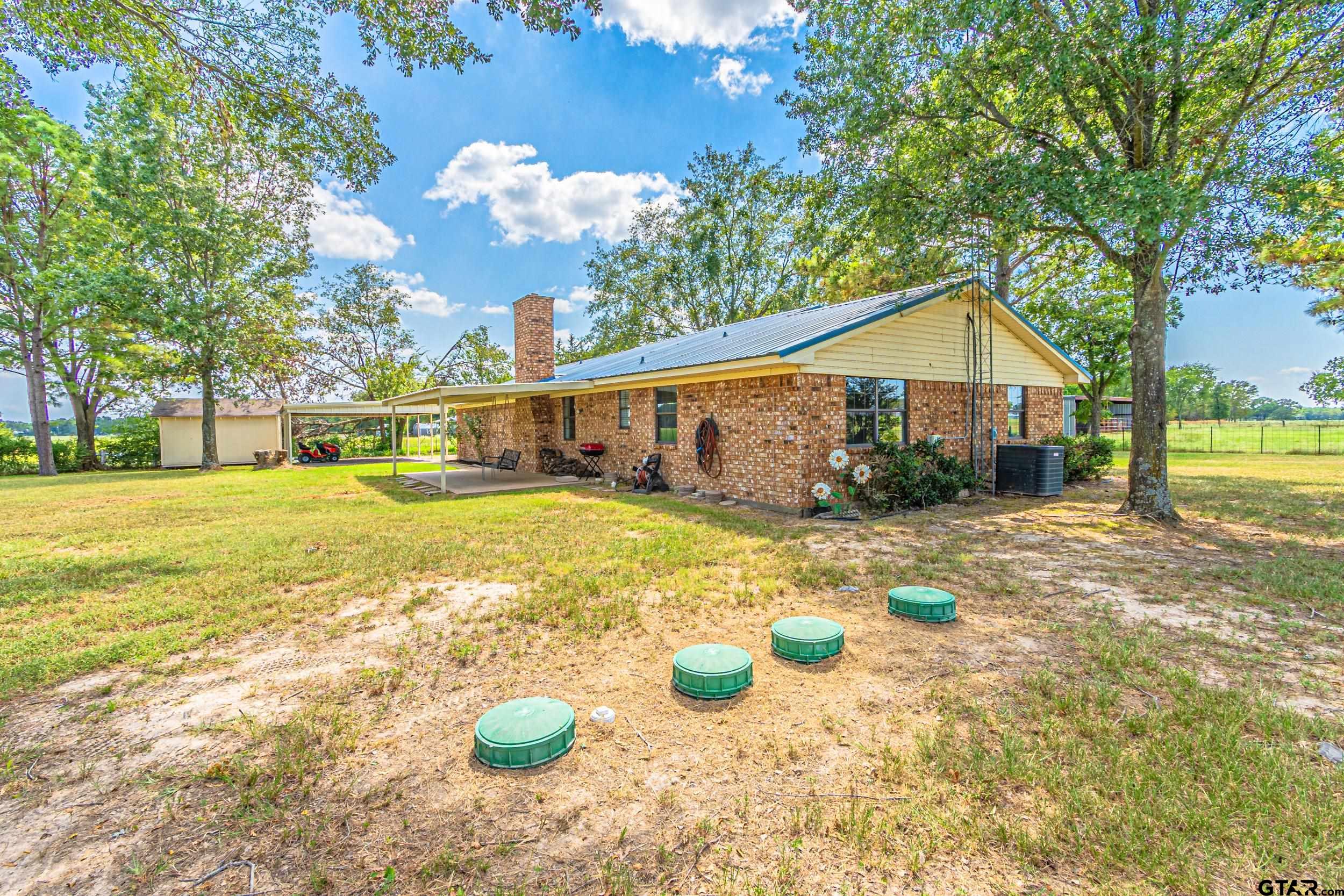 401 VZ County Road Canton, TX 75103 - Photo 40 of 45 a view of a backyard with table and chairs under an umbrella