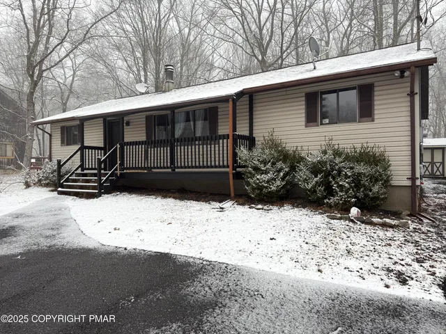 a view of a house with a yard covered in snow