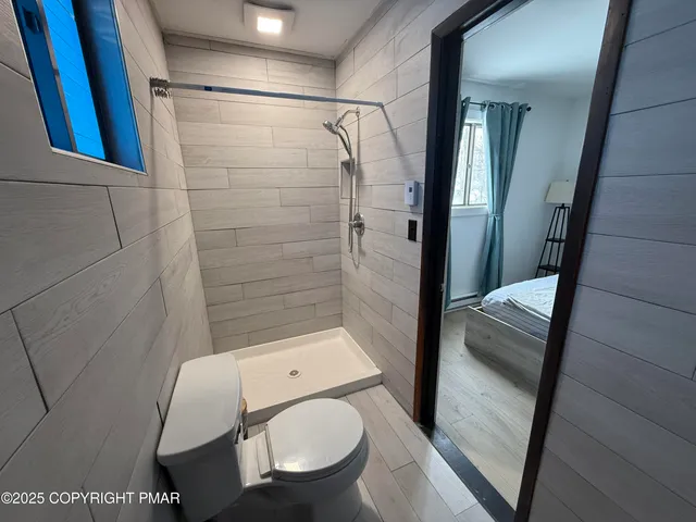 a bathroom with a toilet and a shower