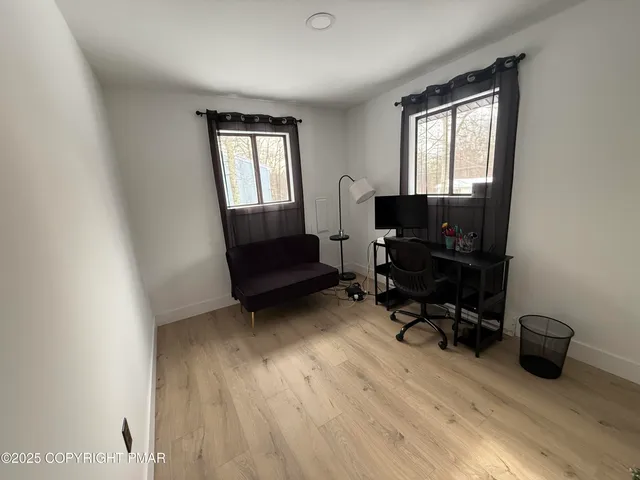 a view of a livingroom with workspace and a window