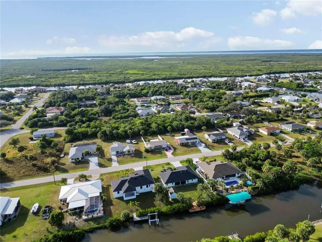an aerial view of a city with lots of residential buildings ocean and mountain view in back