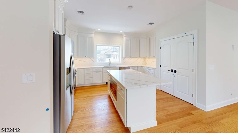 376 5th Avenue Paterson, NJ 07514 - Photo 3 of 20 a kitchen with a sink a counter top space stainless steel appliances and cabinets