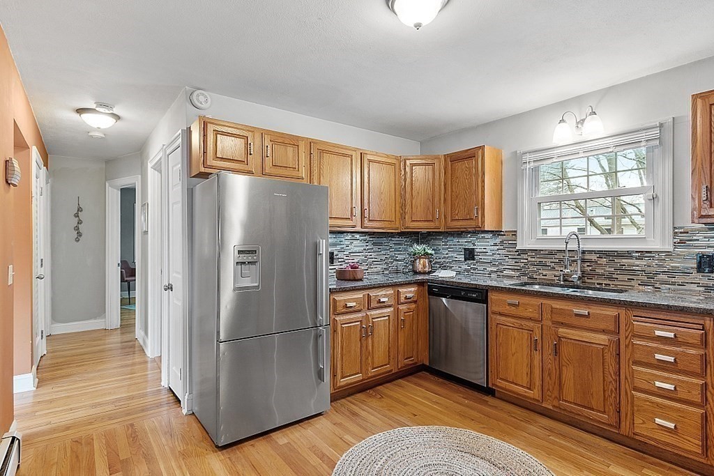 311 High Street Hampton, NH 03842 - Photo 5 of 21 a kitchen with granite countertop stainless steel appliances a refrigerator cabinets and wooden floor