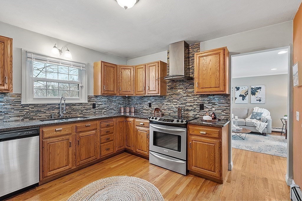 311 High Street Hampton, NH 03842 - Photo 6 of 21 a kitchen with stainless steel appliances granite countertop wooden cabinets a sink a stove a dining table and chairs