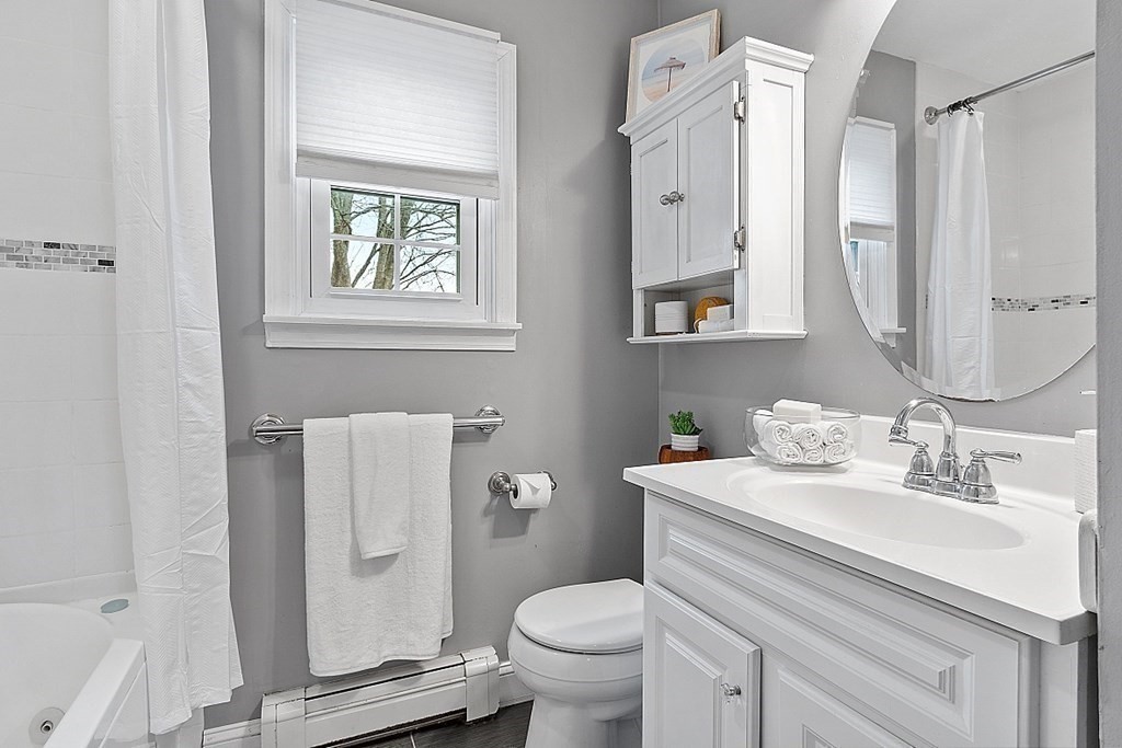 311 High Street Hampton, NH 03842 - Photo 10 of 21 a bathroom with a toilet sink vanity and mirror