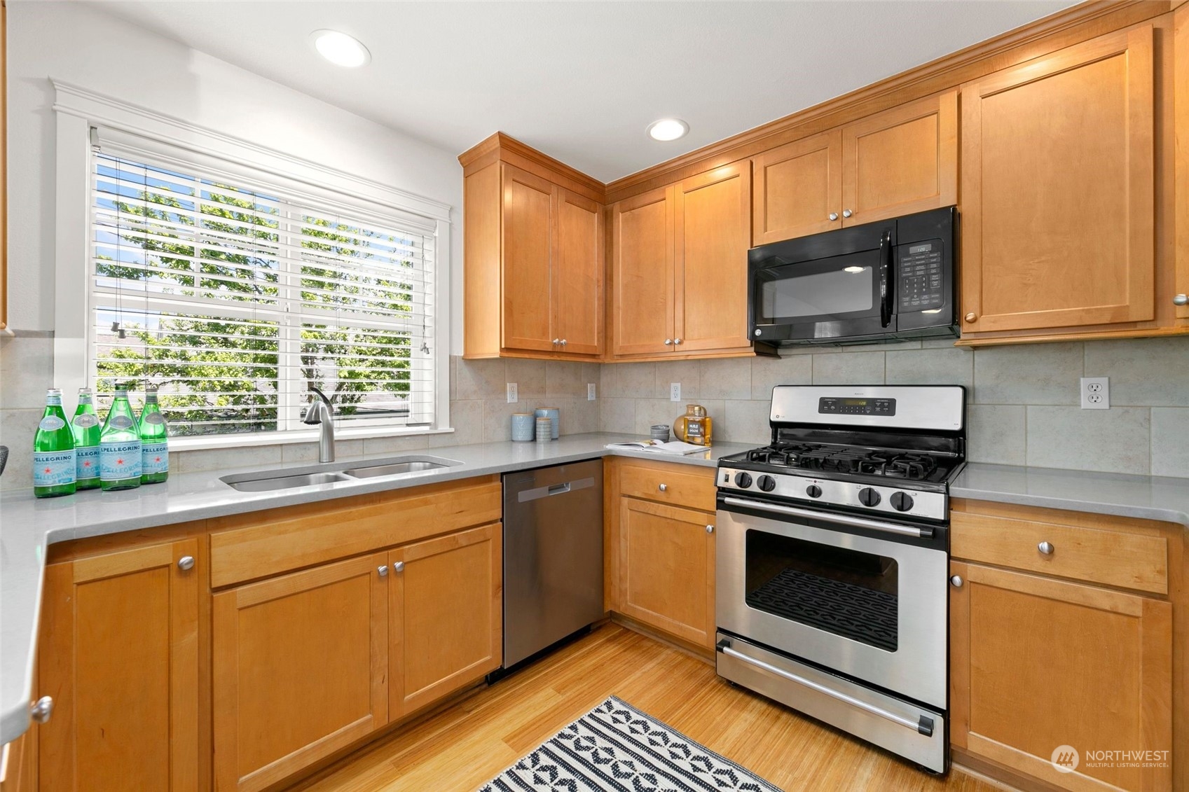 2622 East Union Street Seattle, WA 98122 - Photo 5 of 30 a kitchen with stainless steel appliances a stove a sink and a microwave
