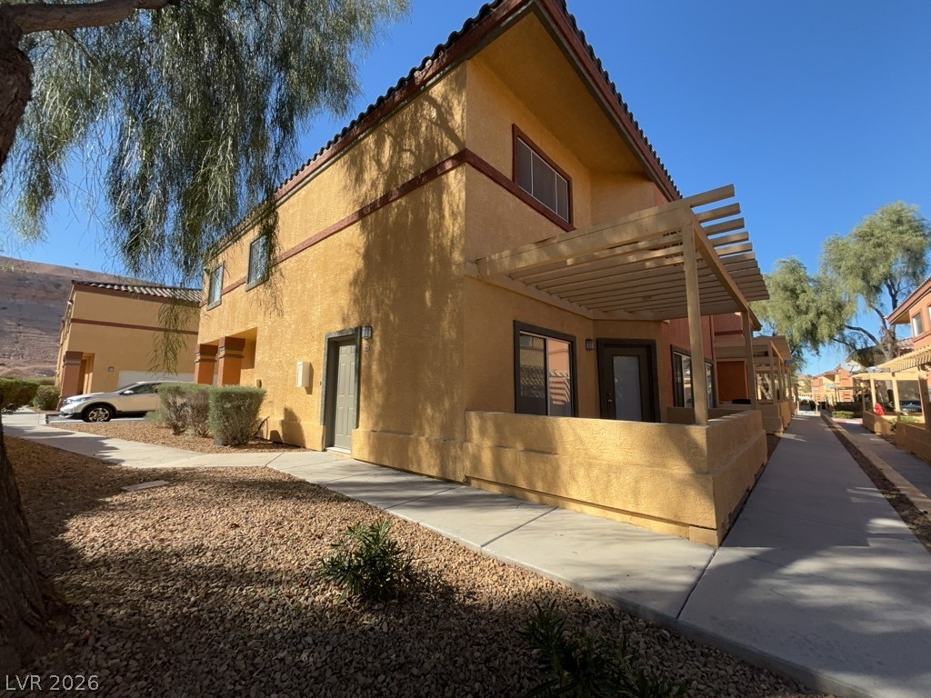 4915 East Russell Road, Unit 142 Las Vegas, NV 89120 - Photo 9 of 10 A welcoming façade with a shaded entrance leads to a sun-drenched pathway.