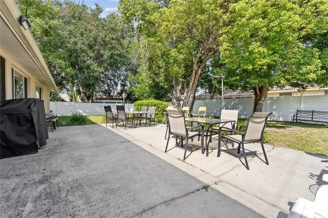 a view of a patio with a table and chairs next to a yard