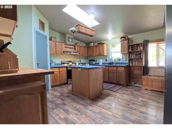 a kitchen with stainless steel appliances granite countertop a stove a sink dishwasher and a refrigerator